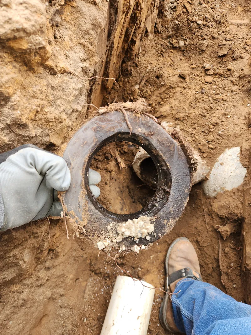 Corroded sewer pipe hub showing deterioration from decades of use in a Northern Utah home